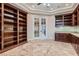 Office featuring custom built-in shelving, granite counters, and glass French doors at 7521 Prancing Pony Ct, Las Vegas, NV 89131
