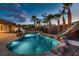 Backyard oasis showcasing a luxurious pool with waterfalls, slide, and lush landscaping at 7521 Prancing Pony Ct, Las Vegas, NV 89131