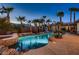 Resort-style pool area with a slide, waterfall features, and mature palm trees at 7521 Prancing Pony Ct, Las Vegas, NV 89131