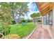 A beautifully landscaped backyard featuring a covered patio and an open grassy area at 7533 Grenfell Dr, Las Vegas, NV 89129