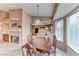 Cozy dining area adjacent to kitchen, featuring a fireplace, and large windows that offer ample natural light at 7533 Grenfell Dr, Las Vegas, NV 89129