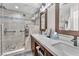 Modern bathroom featuring double sinks, quartz countertop, and a glass shower with designer tile at 7860 Villa Del Fuego, Las Vegas, NV 89131