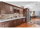 Contemporary kitchen features ample dark cabinets, tile backsplash, stainless steel appliances, and wood flooring at 7860 Villa Del Fuego, Las Vegas, NV 89131