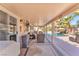 Covered patio area with seating, offering a great view of the pool and backyard, perfect for outdoor dining at 7860 Villa Del Fuego, Las Vegas, NV 89131