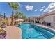 Inviting backyard pool area with lounge chairs, palm trees, and a covered patio at 7860 Villa Del Fuego, Las Vegas, NV 89131