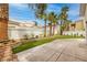Landscaped backyard with artificial grass, palm trees, and a serene atmosphere at 7968 Marbella Cir, Las Vegas, NV 89128