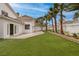 Expansive backyard featuring artificial turf, palm trees, and a retaining wall for landscaping at 7968 Marbella Cir, Las Vegas, NV 89128