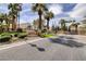 Welcoming entrance to Pelican Point with lush landscaping, a guard gate, and palm trees at 7968 Marbella Cir, Las Vegas, NV 89128
