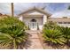 Inviting front entry showcasing a patterned glass front door, arched window, and lush landscaping at 7968 Marbella Cir, Las Vegas, NV 89128