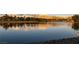Scenic lake view reflecting the warm sunset colors, framed by trees and distant mountains at 7968 Marbella Cir, Las Vegas, NV 89128