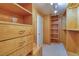 Custom walk-in closet with built-in wooden shelves, drawers, and ample storage space at 7968 Marbella Cir, Las Vegas, NV 89128