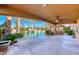 Covered patio features a view of the beautiful pool, bar, palm trees and lush landscaping in the backyard at 8348 Mountain Destiny Ave, Las Vegas, NV 89131