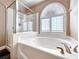An enclosed shower and tub combination with a corner window making a bright, luxury bath at 8348 Mountain Destiny Ave, Las Vegas, NV 89131