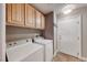 Functional laundry area featuring a washer, dryer, storage cabinets, and convenient access door at 8348 Mountain Destiny Ave, Las Vegas, NV 89131