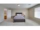 Comfortable bedroom featuring neutral walls, carpet, and a full-size bed near the bathroom at 8407 Kettledrum St, Las Vegas, NV 89139