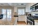Open kitchen with granite countertops, stainless appliances, and a view of the backyard pool at 8407 Kettledrum St, Las Vegas, NV 89139