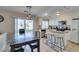 Well-lit kitchen with white cabinets, stainless steel appliances, and a breakfast bar with stools at 8407 Kettledrum St, Las Vegas, NV 89139