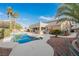 The backyard features a swimming pool, built in bar, covered patio and desert landscaping at 8412 Starstruck Ave, Las Vegas, NV 89143