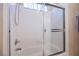 Bathroom features a tub and shower combination with tile surround and glass sliding door at 8412 Starstruck Ave, Las Vegas, NV 89143