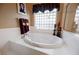Bathroom showcasing a soaking tub with stylish fixtures and a unique window design at 8412 Starstruck Ave, Las Vegas, NV 89143