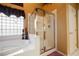Bathroom featuring a glass-enclosed shower, tub, and a window with a unique design at 8412 Starstruck Ave, Las Vegas, NV 89143