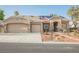 Inviting exterior showcasing a three-car garage, solar panels, desert landscaping, and a charming entrance at 8412 Starstruck Ave, Las Vegas, NV 89143