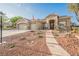 Attractive front exterior featuring desert landscaping, stone accents, a three-car garage, and solar panels at 8412 Starstruck Ave, Las Vegas, NV 89143