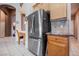 Kitchen features a stainless steel refrigerator, wooden cabinets, and tiled floors at 8412 Starstruck Ave, Las Vegas, NV 89143