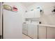 Bright laundry room with washer, dryer, freezer and white cabinets at 8412 Starstruck Ave, Las Vegas, NV 89143