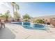 Backyard swimming pool surrounded by desert landscaping, tall palm trees and a brick perimeter fence at 8412 Starstruck Ave, Las Vegas, NV 89143