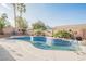 Backyard swimming pool surrounded by desert landscaping, tall palm trees and a brick perimeter fence at 8412 Starstruck Ave, Las Vegas, NV 89143