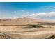 Desert landscape view with distant mountains under a bright blue sky and scattered clouds in an open space at 8412 Starstruck Ave, Las Vegas, NV 89143