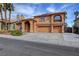 This two-story home has an arched front and three-car garage at 8716 Castle Hill Ave, Las Vegas, NV 89129