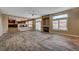 Open-concept living room features a fireplace, ceiling fan, and has an easy flow into the kitchen at 8716 Castle Hill Ave, Las Vegas, NV 89129