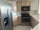 A view of the kitchen featuring wood cabinets, stainless steel appliances, and tiled countertops at 900 Heavenly Hills Ct # 219, Las Vegas, NV 89145