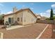 A backyard featuring a stucco wall, grill, wooden table, and desert landscaping at 9051 Sandy Slate Way, Las Vegas, NV 89123