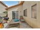 A backyard patio featuring a grill, wooden table, and lounge chair with a window at 9051 Sandy Slate Way, Las Vegas, NV 89123