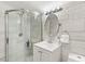 Bathroom featuring a shower with glass doors, white marble tile, and a single sink vanity at 9096 Becket Ranch Ct, Las Vegas, NV 89113