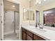 Bathroom features a vanity, white countertop, framed mirrors, a walk-in shower and tile flooring at 9096 Becket Ranch Ct, Las Vegas, NV 89113