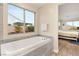 Soaking tub offers natural light, neighborhood views, and easy access to the main bedroom at 9096 Becket Ranch Ct, Las Vegas, NV 89113