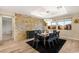 Dining room with large windows, modern lighting, and decorative stone wall at 9096 Becket Ranch Ct, Las Vegas, NV 89113