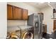 Spacious laundry room boasts stainless steel appliances, including a washer, dryer, and refrigerator at 9096 Becket Ranch Ct, Las Vegas, NV 89113