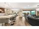 Open floor plan with kitchen, dining and living room areas featuring tile floors and access to backyard patio at 9096 Becket Ranch Ct, Las Vegas, NV 89113