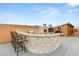 An outdoor kitchen offers a bar for six, granite countertop, and stainless steel barbecue at 9096 Becket Ranch Ct, Las Vegas, NV 89113