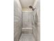 Walk-in shower with gray-tone tiling, a shower bench, hand-held spray, and traditional shower head at 9096 Becket Ranch Ct, Las Vegas, NV 89113