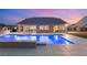 Beautiful backyard featuring a sparkling pool, covered patio, outdoor kitchen, and elegant home exterior at 9096 Becket Ranch Ct, Las Vegas, NV 89113
