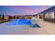 Backyard featuring a sparkling blue pool, outdoor kitchen, and elegantly landscaped seating area at 9096 Becket Ranch Ct, Las Vegas, NV 89113