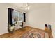 Bright bedroom with a large window, modern decor, and wood flooring at 9926 Swimming Hole St, Las Vegas, NV 89183