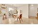 Bright dining area with tile flooring, a modern white table, and a sliding glass door to the outdoor patio at 9926 Swimming Hole St, Las Vegas, NV 89183