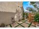 Charming patio with stone tiles, artificial turf accents, and comfortable seating perfect for enjoying the outdoors at 9926 Swimming Hole St, Las Vegas, NV 89183